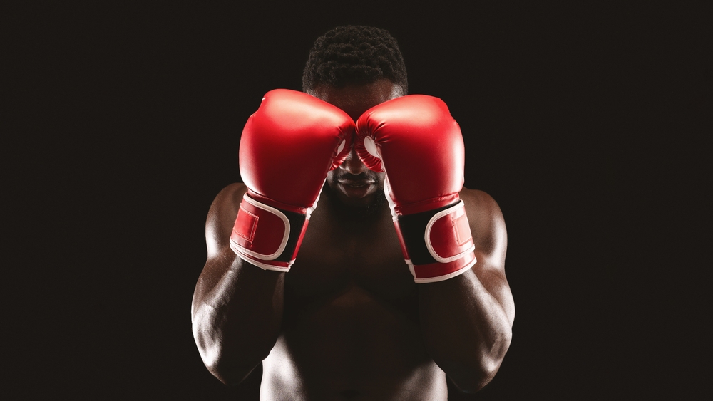  boxer with red gloves raised to his face