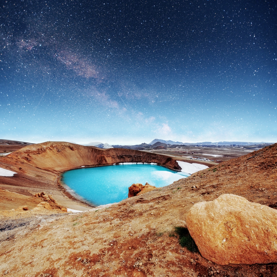 milky way over a turquoise pool of water