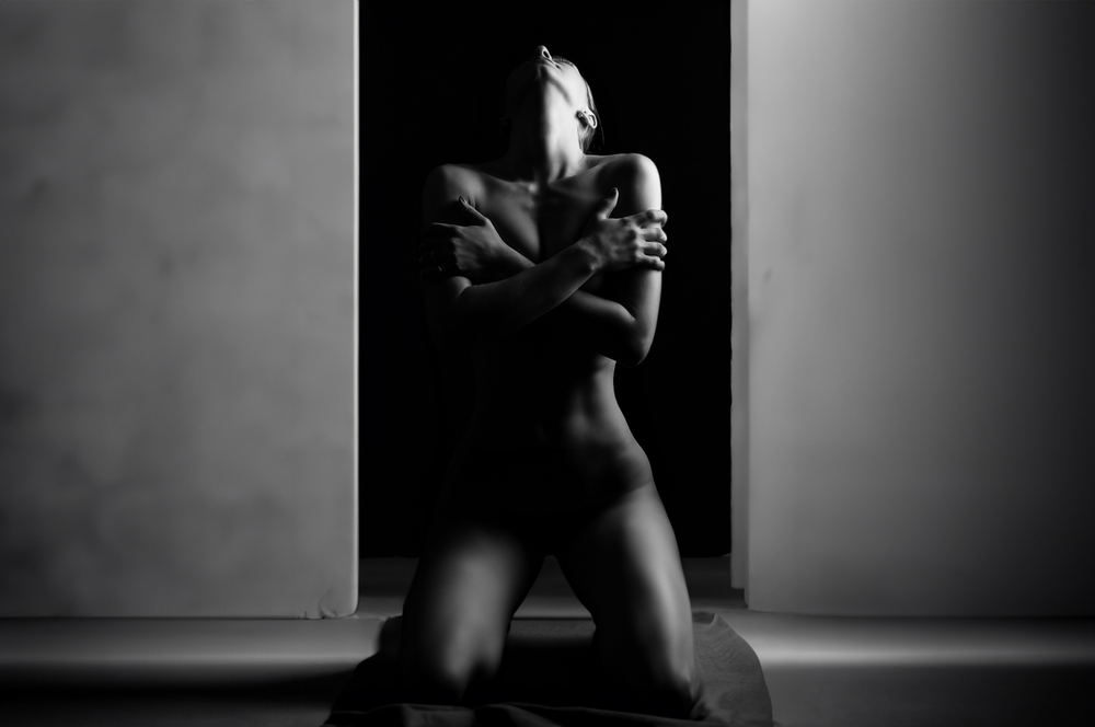 Nude woman with crossed arms kneeling