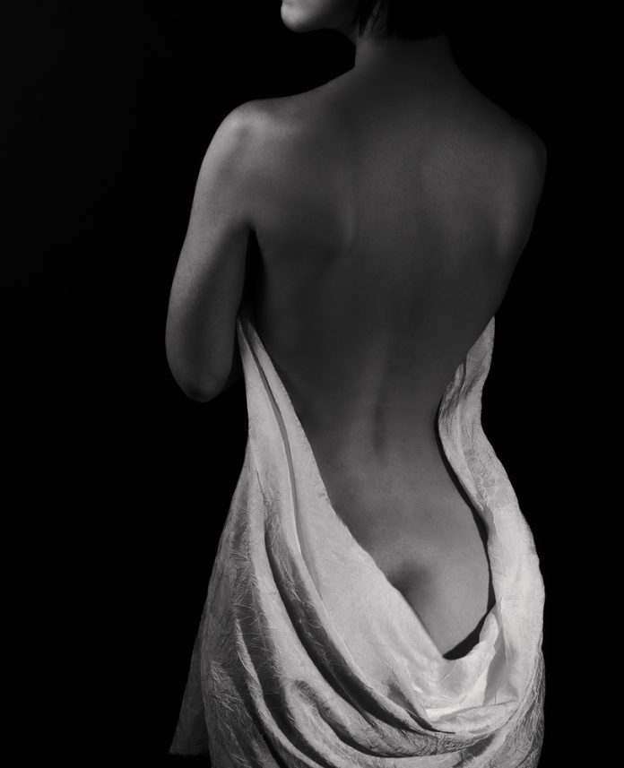 Nude woman's back with drape BW