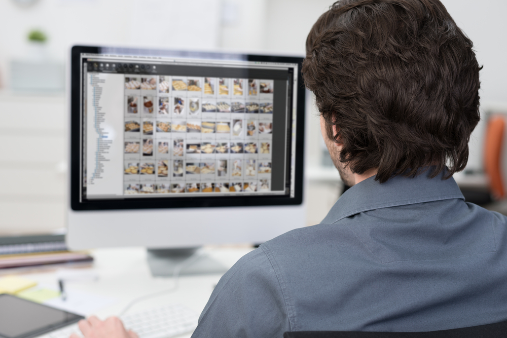 man organizing photos on computer