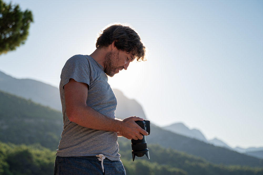 photographer checking the settings on display of his dslr camera