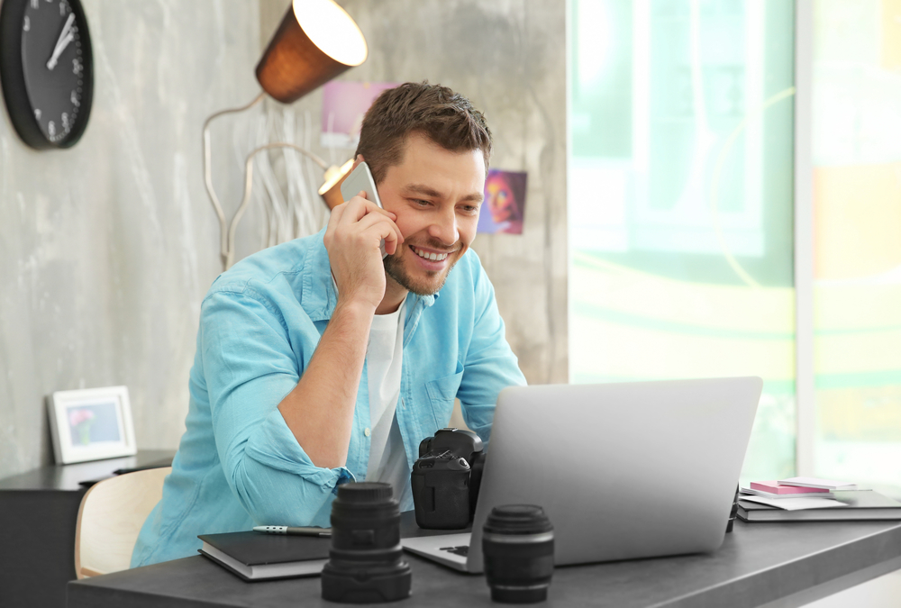 Photographer in his office and talking on phone