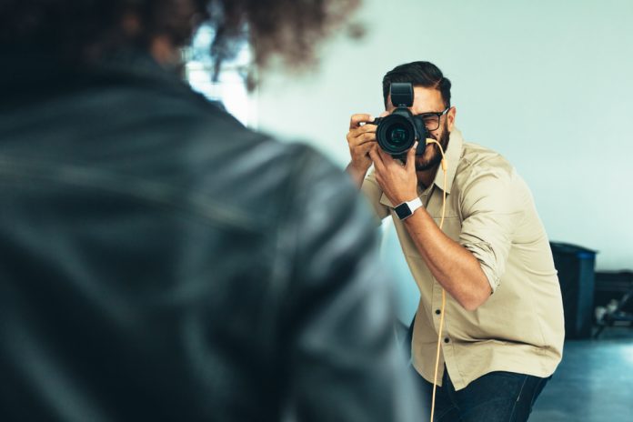 Photographer shooting photographs of a model in a studio