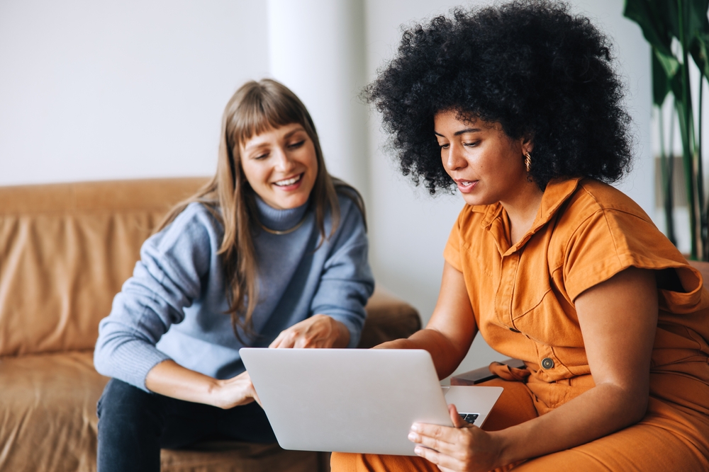 Two women talking with a laptop